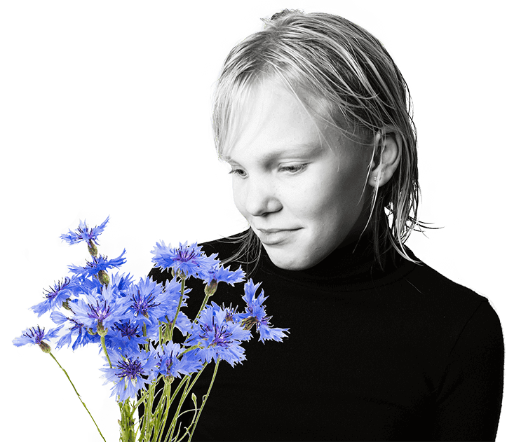 Autismport - dívka se dívá na svazek fialových kytek